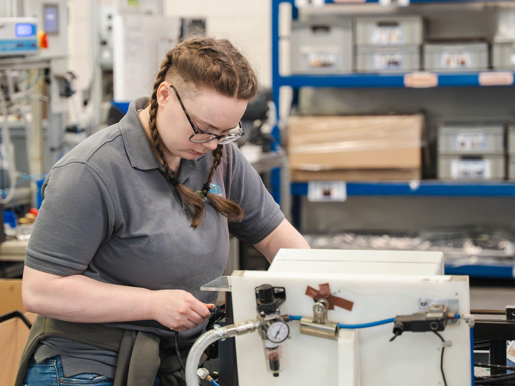 An Evtec team member assembling components at a workbench