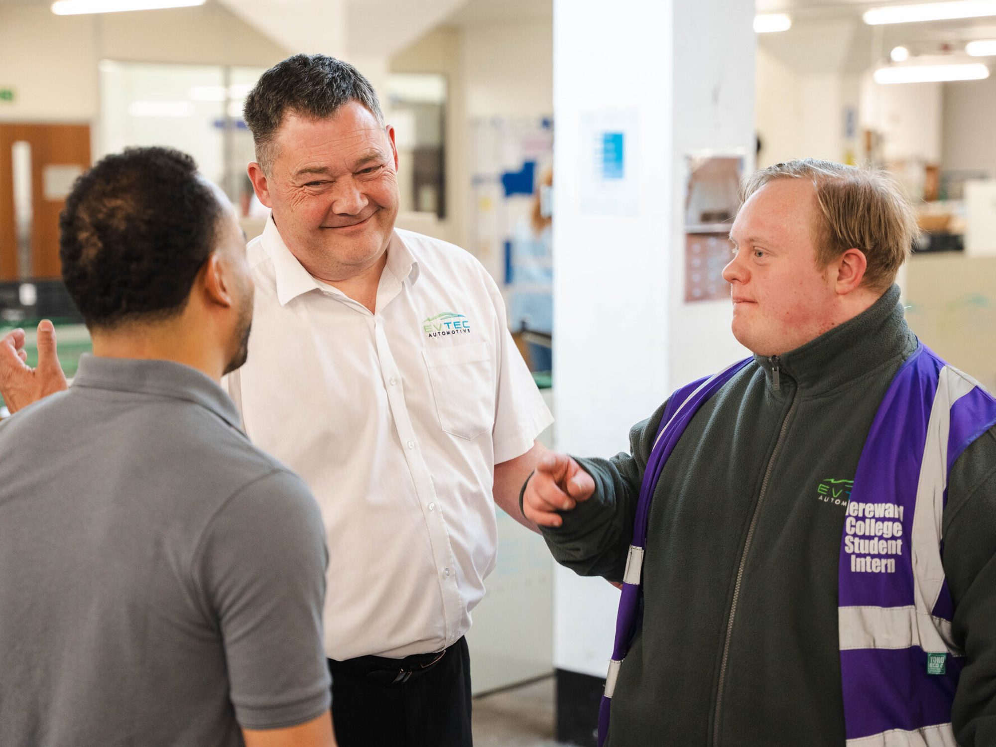 Two Evtec colleagues talking and laughing together outside the building